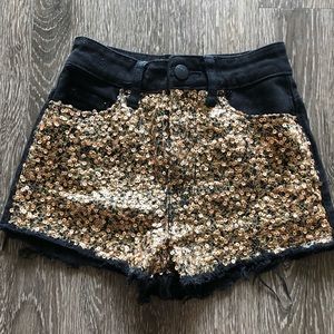 Black denim and gold sequin high-waisted shorts.